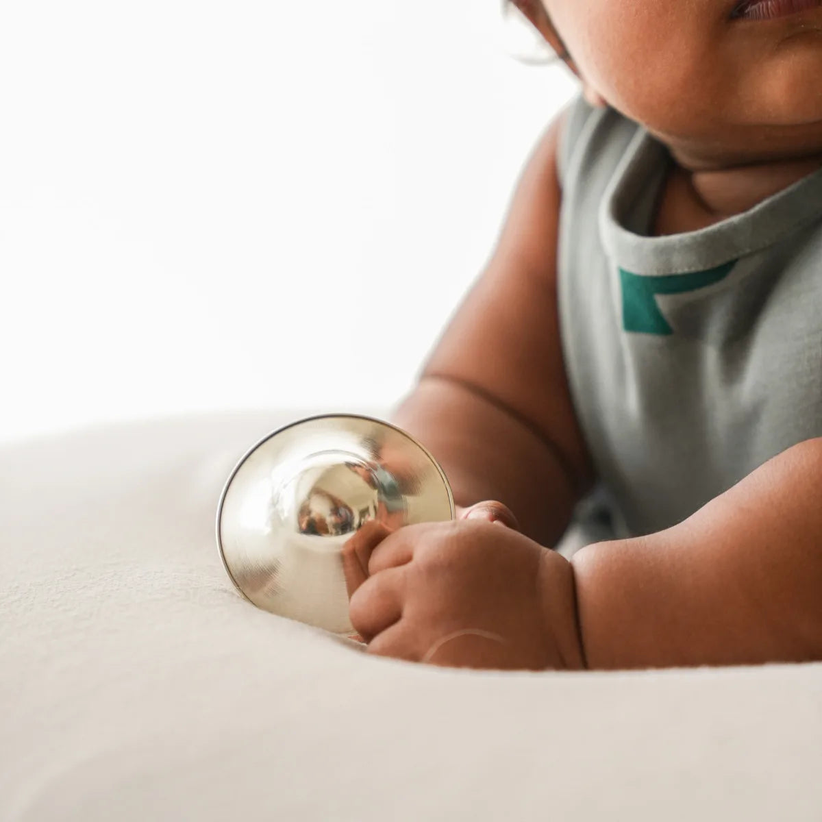 Child holding a Silver Nurture nursing cup